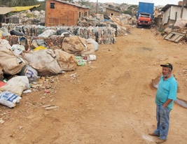 REAQUECIMENTO -Romildo Garcia Vilar, proprietário do depósito de sucatas no Jardim Aeroporto, é visto próximo a caminhões e montanhas de recicláveis: ele comemora a retomada do setor neste ano